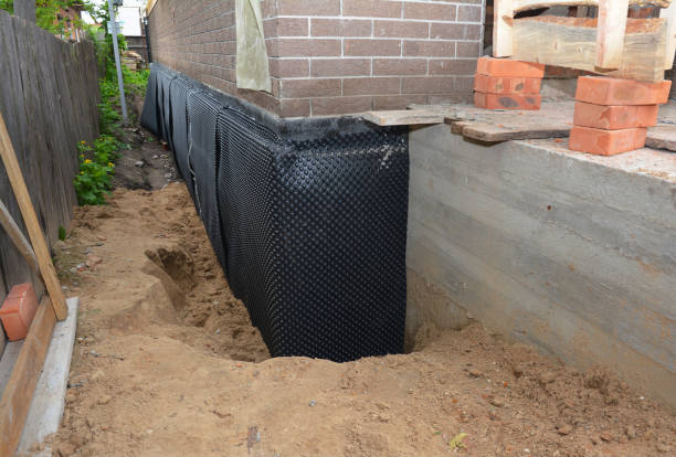 SJ Waterproofing Pros technician performing targeted Wet Basement Repair assessment in Wyandanch, NY